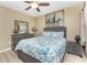 Cozy bedroom with light wood floors, ceiling fan, and comfortable bed with matching furniture at 7049 Waterford Pkwy, Punta Gorda, FL 33950