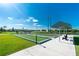 Relaxing community bocce ball courts beside a serene lake with seating areas and shade structures at 7049 Waterford Pkwy, Punta Gorda, FL 33950