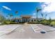 Clubhouse exterior featuring well-manicured landscaping, palm trees, and accessible parking spaces at 7049 Waterford Pkwy, Punta Gorda, FL 33950