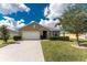 Beautiful single Gathering home featuring a manicured lawn, mature trees, and a spacious two car garage at 7049 Waterford Pkwy, Punta Gorda, FL 33950