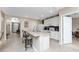 Bright open kitchen with white cabinets, countertop seating, and an archway leading to the foyer at 7049 Waterford Pkwy, Punta Gorda, FL 33950