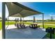 Outdoor community picnic area featuring picnic tables, barbecue grills, and shaded seating under a sunny sky at 7049 Waterford Pkwy, Punta Gorda, FL 33950