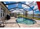 Beautiful pool in screened lanai overlooking a scenic lake view and lush green landscaping at 7049 Waterford Pkwy, Punta Gorda, FL 33950