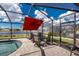 Sparkling pool inside screened lanai featuring outdoor dining, scenic water views, and blue skies at 7049 Waterford Pkwy, Punta Gorda, FL 33950