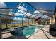 Relaxing screened pool area with a heated pool, spa, and beautiful lake view at 7049 Waterford Pkwy, Punta Gorda, FL 33950
