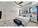 Bright main bedroom featuring a tray ceiling, a king bed, and large windows with blue curtains at 11637 Woodleaf Dr # 11637, Bradenton, FL 34211