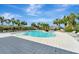 Community pool with lounge chairs, umbrellas, and tropical landscaping under a sunny sky at 11637 Woodleaf Dr # 11637, Bradenton, FL 34211