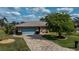 Aerial view of a well-maintained home with a two-car garage, lush lawn, and a patterned driveway at 1212 Yachtsman Ln, Punta Gorda, FL 33983