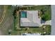 Aerial view of a home with a screened pool, well-maintained landscaping, and a paved driveway at 1212 Yachtsman Ln, Punta Gorda, FL 33983