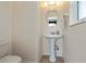 Well-lit half bathroom featuring pedestal sink and an oval mirror at 1212 Yachtsman Ln, Punta Gorda, FL 33983