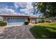 Charming single-story home with a blue garage door, lush lawn, and stone-paved driveway at 1212 Yachtsman Ln, Punta Gorda, FL 33983