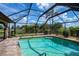 Sparkling pool surrounded by a screened enclosure and lush landscaping creating a private oasis at 1212 Yachtsman Ln, Punta Gorda, FL 33983