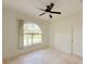 Bedroom featuring neutral walls, travertine tile flooring, and an arched window at 1259 Royal Tern Dr, Punta Gorda, FL 33950