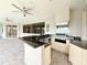 This outdoor kitchen features bar seating, a stainless steel grill, an exhaust hood, and a ceiling fan at 1259 Royal Tern Dr, Punta Gorda, FL 33950