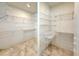 Spacious walk-in closet with adjustable metal shelving and travertine flooring at 1259 Royal Tern Dr, Punta Gorda, FL 33950