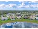 This aerial view captures homes with screened lanais situated on a pond, reflecting blue skies and the neighborhood's beauty at 1578 Scarlett Ave, North Port, FL 34289