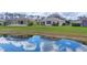 Scenic backyard with a pond view reflecting the sky, complemented by well-maintained landscaping at 1578 Scarlett Ave, North Port, FL 34289