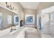 Elegant bathroom with a soaking tub, separate shower, dual sinks, and stylish fixtures at 1578 Scarlett Ave, North Port, FL 34289