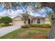 Charming single Gathering home featuring a manicured front yard and an attached two-car garage at 1578 Scarlett Ave, North Port, FL 34289