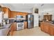 A kitchen featuring stainless steel appliances, wood cabinetry, and tile flooring at 1578 Scarlett Ave, North Port, FL 34289