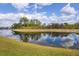 Scenic view of a tranquil pond reflecting the blue sky and surrounding trees at 1578 Scarlett Ave, North Port, FL 34289