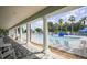 Covered porch view of a sparkling community pool with lounge chairs and a secure fence for residents to enjoy at 1578 Scarlett Ave, North Port, FL 34289