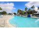 Beautiful community pool with light blue water, palm trees and a clear blue sky at 1578 Scarlett Ave, North Port, FL 34289