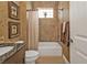 Tiled bathroom with a granite countertop and a shower-tub combination with stylish decor at 1620 Lancashire Dr, Venice, FL 34293