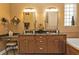 Bathroom featuring dual sinks, granite countertops, decorative mirrors, and a bathtub at 1620 Lancashire Dr, Venice, FL 34293