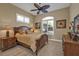 Cozy bedroom with wood furniture, a ceiling fan, plantation shutters and neutral tones at 1620 Lancashire Dr, Venice, FL 34293