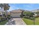 Well-maintained home featuring a tile roof, manicured landscaping, and a paved driveway at 1620 Lancashire Dr, Venice, FL 34293