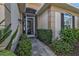 Inviting front entrance with a screened porch and stone pathway surrounded by manicured bushes at 1620 Lancashire Dr, Venice, FL 34293