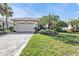 Charming home with a tile roof, paver driveway, lush landscaping, and a well-manicured lawn at 1620 Lancashire Dr, Venice, FL 34293