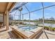 An outdoor screened-in patio featuring a gorgeous hot tub and beautiful lakeside views at 1620 Lancashire Dr, Venice, FL 34293