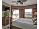 Relaxing main bedroom featuring large windows, balcony access, and a flat-screen TV at 1620 Lancashire Dr, Venice, FL 34293