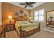 Comfortable bedroom featuring wood furniture, a ceiling fan and warm lighting at 1620 Lancashire Dr, Venice, FL 34293