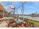 Screened-in patio showcases a beautiful lake view and cozy outdoor seating area at 1620 Lancashire Dr, Venice, FL 34293