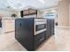 Kitchen island featuring stainless steel microwave, dark wood cabinets, and granite countertops in an open layout at 17122 Barcrest Ln, Punta Gorda, FL 33955