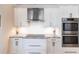 Close-up of the kitchen showcasing modern stainless steel appliances, custom cabinetry, and stylish backsplash at 17122 Barcrest Ln, Punta Gorda, FL 33955