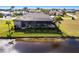 Aerial shot showcases the back of a home with a screened in patio and lush landscaping along a water view at 17122 Barcrest Ln, Punta Gorda, FL 33955