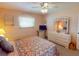 The quaint bedroom with a colorful quilt, dresser, and plenty of natural light at 1727 Boca Raton Ct, Punta Gorda, FL 33950