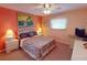 The charming bedroom is painted a peach color, and has a double bed with matching bedside lamps at 1727 Boca Raton Ct, Punta Gorda, FL 33950