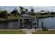 Canal view showcasing a well-maintained boat lift for easy water access at 1727 Boca Raton Ct, Punta Gorda, FL 33950