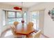 Bright dining room with a wooden table, and views of the outdoor pool through a large window at 1727 Boca Raton Ct, Punta Gorda, FL 33950