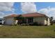 Charming single-story home featuring a red tile roof, well-maintained lawn, and mature landscaping at 1727 Boca Raton Ct, Punta Gorda, FL 33950