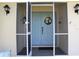 Screened entryway showcasing a blue double door with decorative accents and tiled flooring at 1727 Boca Raton Ct, Punta Gorda, FL 33950