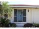 Welcoming screened entryway with a charming blue double door, plants, and a red tile roof above at 1727 Boca Raton Ct, Punta Gorda, FL 33950