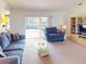 Cozy living room featuring comfortable blue seating and sliding glass doors that offer a pool view at 1727 Boca Raton Ct, Punta Gorda, FL 33950