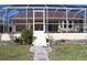 Screened patio with steps leading down to the backyard and tiled flooring at 1727 Boca Raton Ct, Punta Gorda, FL 33950