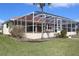 The back of the house features a screened-in pool and lush landscaping at 1727 Boca Raton Ct, Punta Gorda, FL 33950